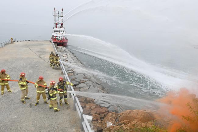 해군인천해역방어사령부 팔미도 해상감시장비운용대 장병과 소방대원들이 모의화재(연막탄)를 진압하고 있다.  사진 제공 =양성기 상사