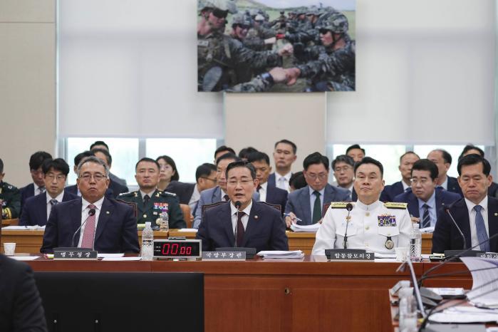 Defense Minister Shin Won Sik (center) answers a q