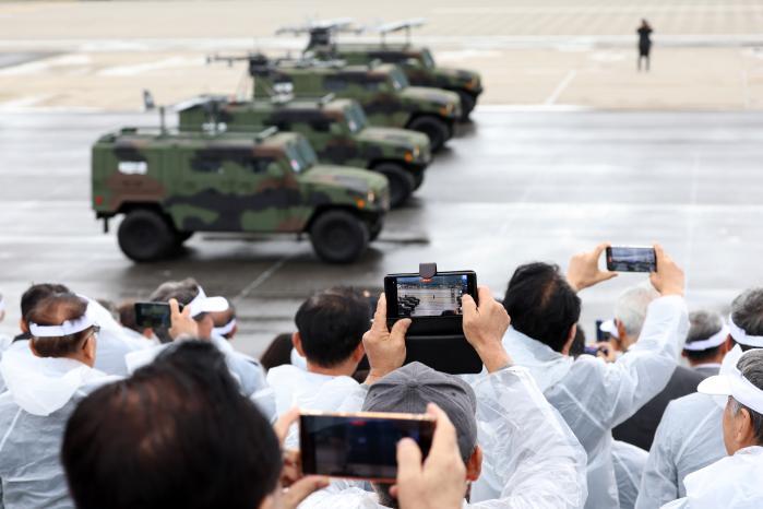 Citizens take pictures of military equipment with 