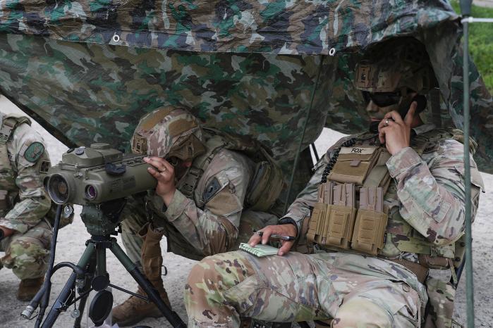  A US forward soldier checks the impact points of a towed howitzer.