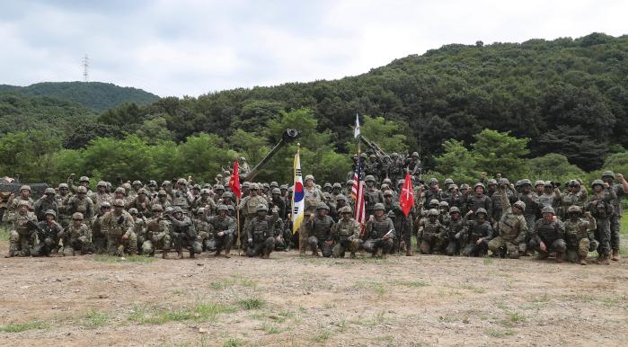  South Korean and US soldiers pose for a picture while shouting.